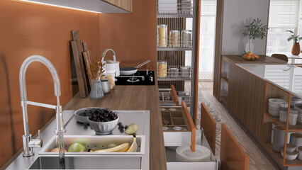 Cozy orange and wooden kitchen close up, open drawers with pottery and utensils. Sink with fruit, induction hob with pots, wooden cutting boards. Contemporary interior design concept