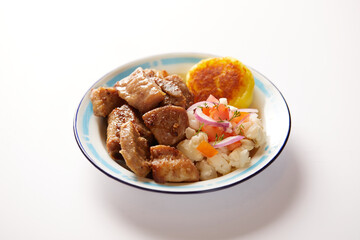 Homemade fritada a typical ecuadorian dish that consists on braised pork. It’s served on a traditional plate with a white background