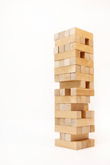 A game of logic and the ability to think. Jenga tower with wooden blocks on a white background. The...