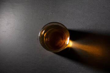 glass with whiskey on a dark background top view
