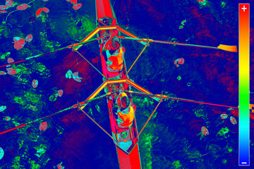 Thermal image of two rowers in a boat, rowing on the tranquil lake - obrazy, fototapety, plakaty
