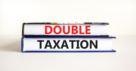 Double taxation symbol. Concept words Double taxation on books on a beautiful white table white background. Business tax and double taxation concept, copy space.