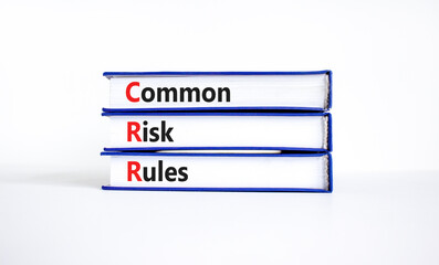 CRR common risk rules symbol. Concept words CRR common risk rules on books on a beautiful white table, white background. Business and CRR common risk rules concept. Copy space.