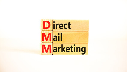 DMM direct mail marketing symbol. Concept words DMM direct mail marketing on wooden blocks on a beautiful white table, white background. Business and DMM direct mail marketing concept. Copy space.