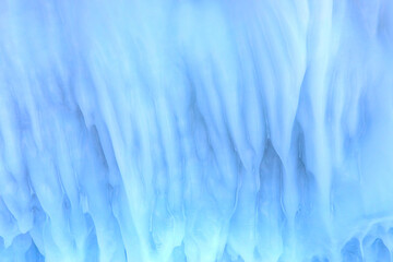 Ice and snow patterns and icicles on rocks in the cave - The rock on the frozen lake Baikal is...
