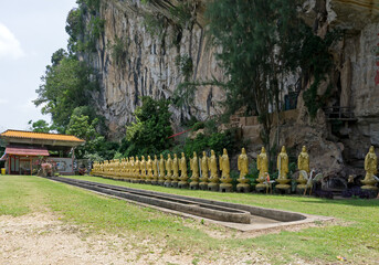 Buddha statues at Perak Kwan Yin Tong temple in Ipoh, Perak, Malaysia. Built beside a limestone...