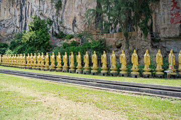 Buddha statues at Perak Kwan Yin Tong temple in Ipoh, Perak, Malaysia. Built beside a limestone...