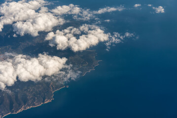 view from the airplane window to mountains clouds and blue sky