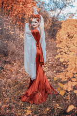 Girl in a long red dress in autumn maidens of rowan