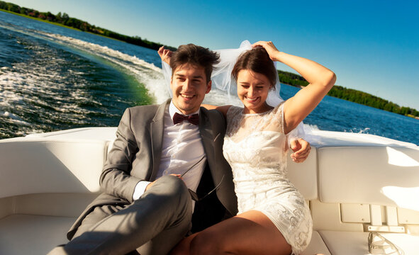 Newlywed. Young couple. Groom and bride. Photo session on a speedboat. Lake