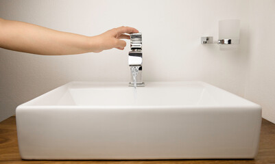 Mano cerrando  grifo de agua abierto, día mundial del agua