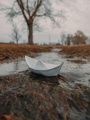 A paper boat floats on a spring stream