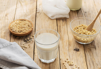 Barley milk in glass on the wooden table with ingredients