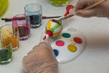 Close up view of hands child to paint Easter eggs with special utensils. Holiday concept. Sweden.