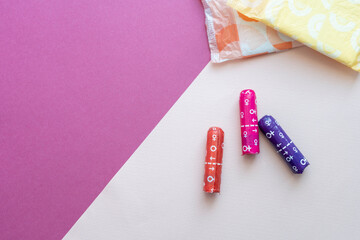 feminine sanitary pads and tampons on pink background