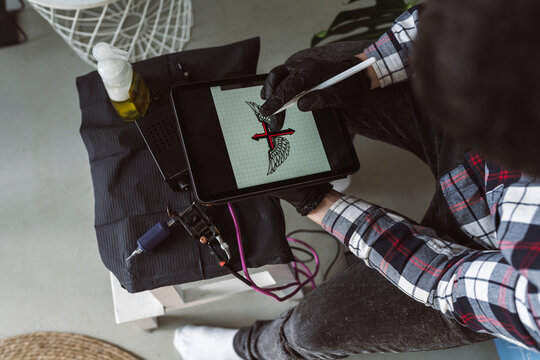male tattoo designer with a tablet, tattoo artist