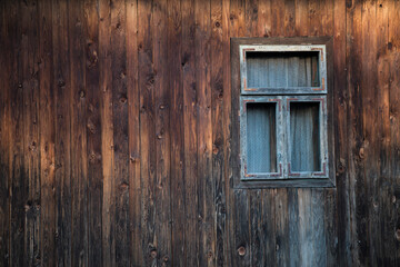 Sunja, Croatia, 05,04,2021: Rustic style aged window in wooden village rural home wall.