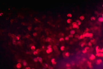 Neon bokeh light. Blur sparks. Festive glitz sparkles. Defocused red color glow shiny sequin...