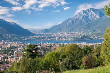 Lake Como and the city of Lecco, italy. Panoramic view from above with Lecco city in the foreground and the towns of Malgrate, Valmadrera and Civate in the background  - obrazy, fototapety, plakaty