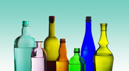 Bottles with wines and spirits on a colored background.