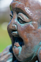 Fototapeta na wymiar Closeup of face on smiling Hotei Buddha statue