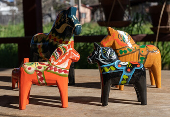 Fototapeta na wymiar A group of Swedish wooden Dala horses in various colors