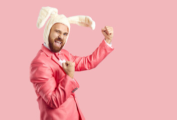 Happy Easter Bunny celebrating success. Funny cheerful confident ginger man wearing white fluffy...