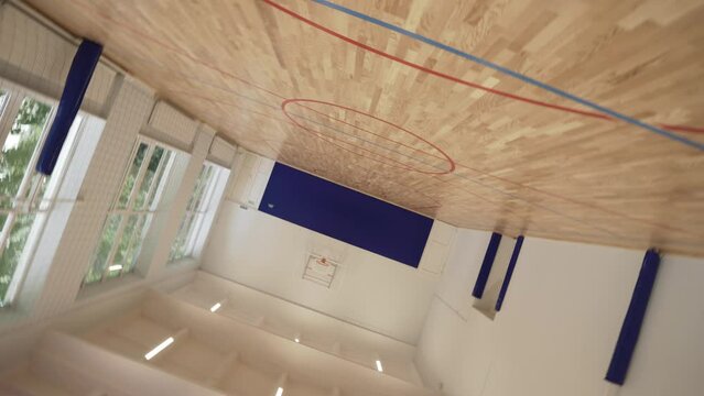 Empty school gym. Basketball hall with wooden parquets.