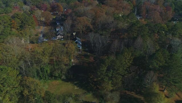 Top down fly over wooded aera with sparse house