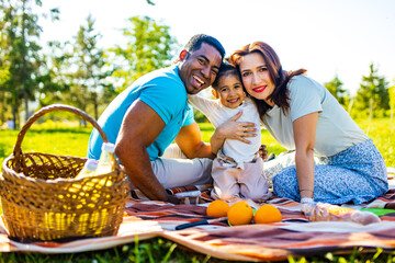Happy international family enjoying picnic in nature