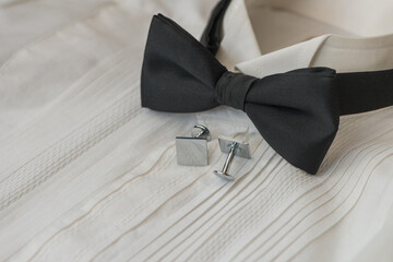 Black bow tie with cufflinks and white evening shirt.Focus to centre of tie with out of focus areas.