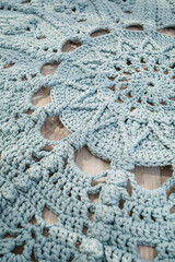 In a bright room on the floor there is a round blue handmade carpet. flooring, natural cotton. Blue knitted handmade carpet on the floor