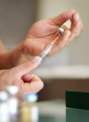 Obraz premium Getting the competitive edge. Closeup of a man filling a syringe with a clear liquid.