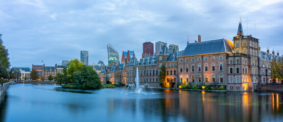 Obraz premium Panoramic photo during a windy day of the Hofvijver and the Binnenhof with the parliament buildings in The Hague, just after sunset and seen from the Buitenhof