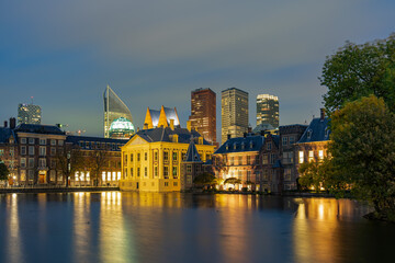 Photo on a windy evening of the Hofvijver with the Mauritshuis and part of the parliament buildings at the Binnenhof and the skyline of The Hague in the background