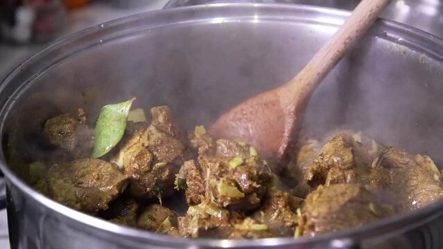 Cooking Jamaican curry goat.  Stirring the pot.  Real time