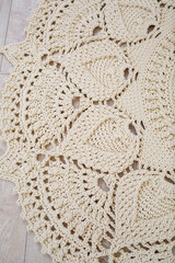 Handmade carpet knitted from natural threads, flooring, natural cotton. Beige handmade carpet. Knitted decorative item