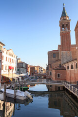 Fototapeta na wymiar View of town Chioggia with canal Vena and church steeple of Chiesa della Santissima Trinita in Veneto, Italy