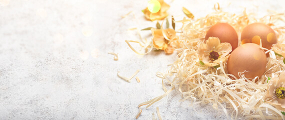 Easter eggs and flowers on light background