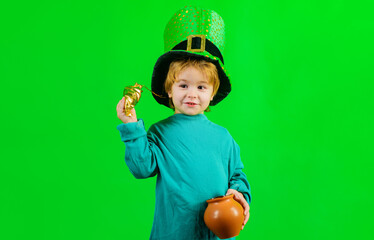 Cute child with pot of gold. Patricks day celebrations. Little boy in Leprechaun hat. Coins. Money.