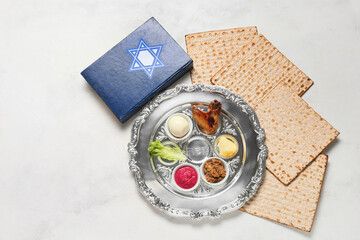 Passover Seder plate with traditional food, matza and Torah on white background