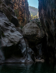huge stone hangs stuck between two rocky walls of the Göynük canyon in Turkey