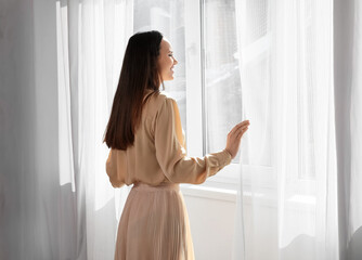 Pretty young woman near window