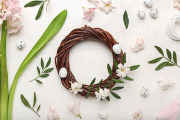 Easter wreath, eggs and floral decor on light background, closeup