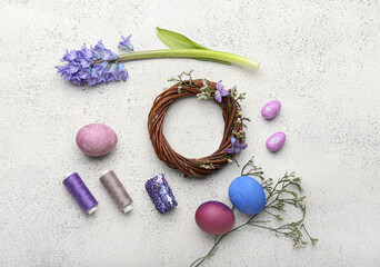 Fototapeta na wymiar Composition with Easter wreath, flowers, eggs and threads on light background