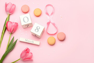 Calendar with date of International Women's Day celebration, macaroons and tulip flowers on pink background