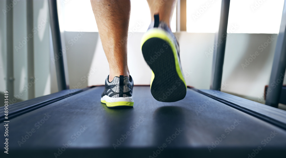 Poster The long walk to fitness. Cropped shot of an unrecognizable man jogging on a treadmill in the gym.