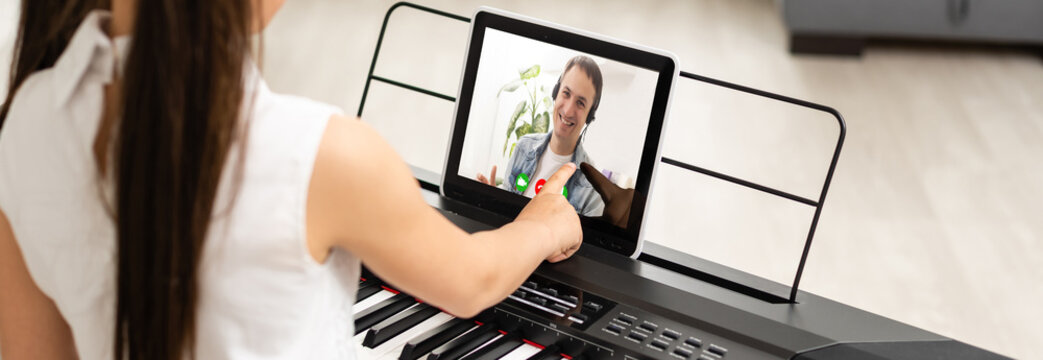 Little girl watching online lesson tutorial how to learn a synthesizer