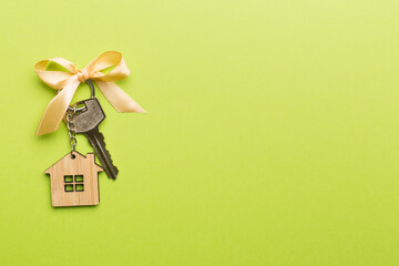 House key with golden bow on color background