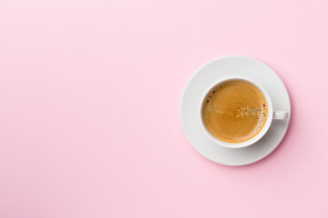 Cup of delicious coffee on color background, top view